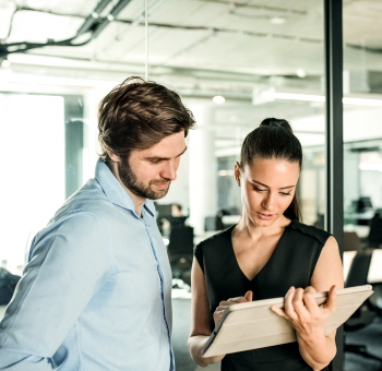 Young businesspeople with tablet in an office, working.